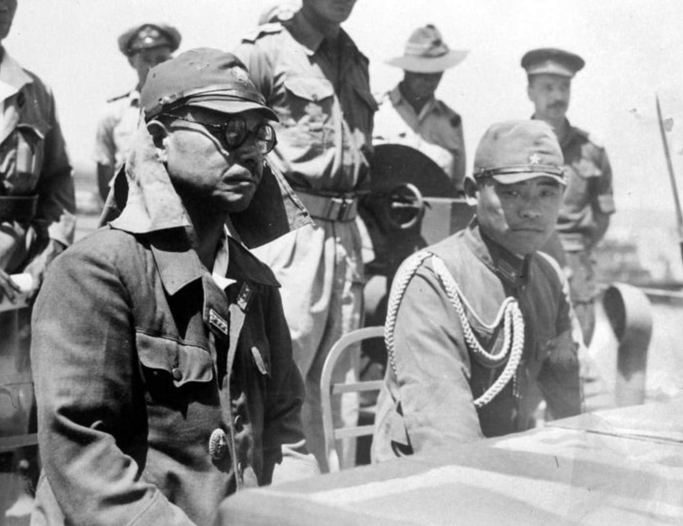Japanese commanders listen to the terms of surrender aboard an Australian warship 